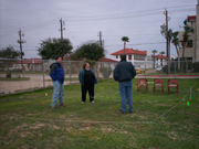 Three sanctuary staff considering the layout of the back deck of the Manta outlined with string and chairs in a field during the planning stages