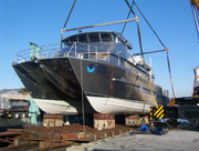 A bow view of a catamaran style vessel resting on the rails that will be used to launch it into the water for the first time.