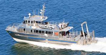 Research vessel MANTA underway on a blue sea.