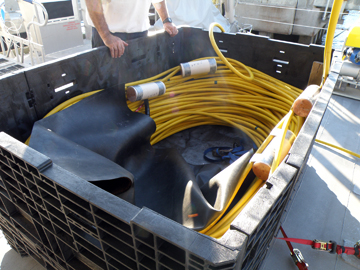 ROV umbilical cable coiled in a large box on the boat deck