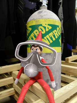 Elf doll wearing a paper dive mask sitting next to a Nitrox scuba tank