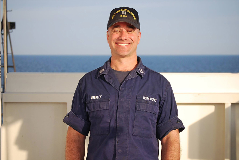 Marc Weekley on a ship with the ocean in the background