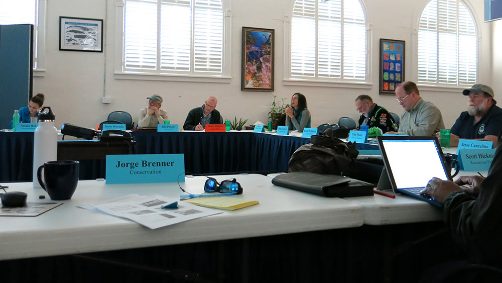 Council members seated around a table with their name plates in front of them designating their council seats.