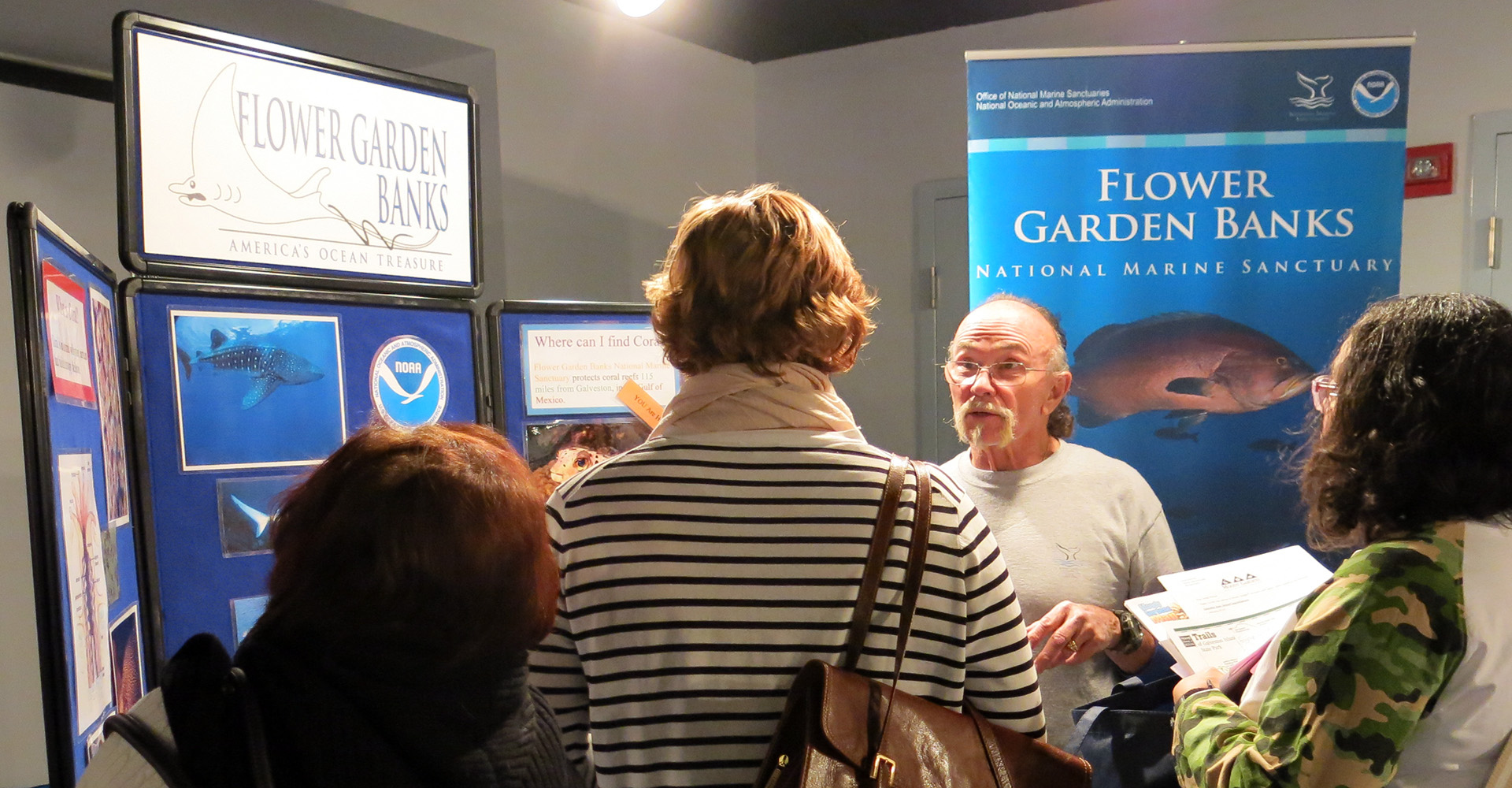 Volunteer talking to visitors at a sanctuary display booth